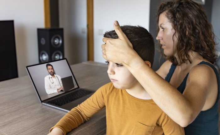 Telemedicina pediátrica: mãe e filho em atendimento online com pediatra pelo computador