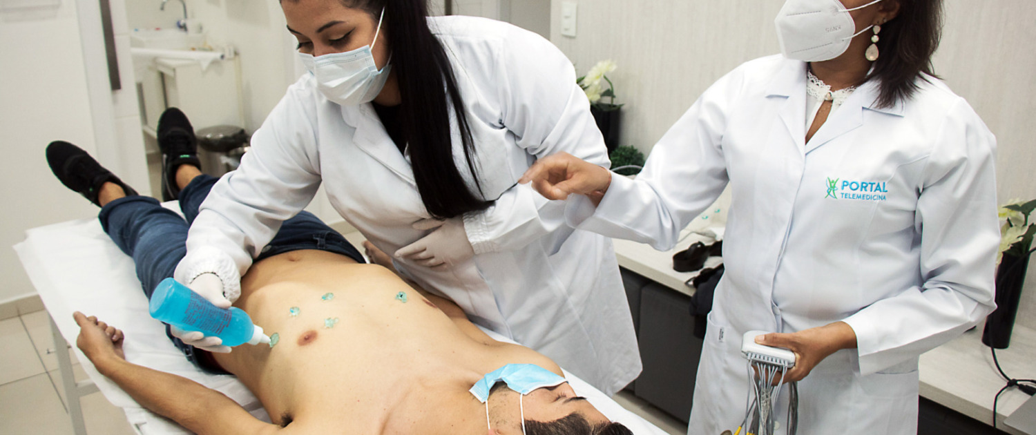 mujeres realizando electrocardiograma en paciente
