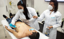 mujeres realizando electrocardiograma en paciente
