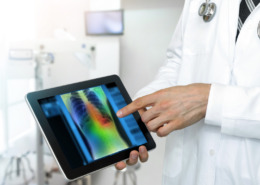 medico con un tablet usando inteligencia artificial en la salud para analizar estudio