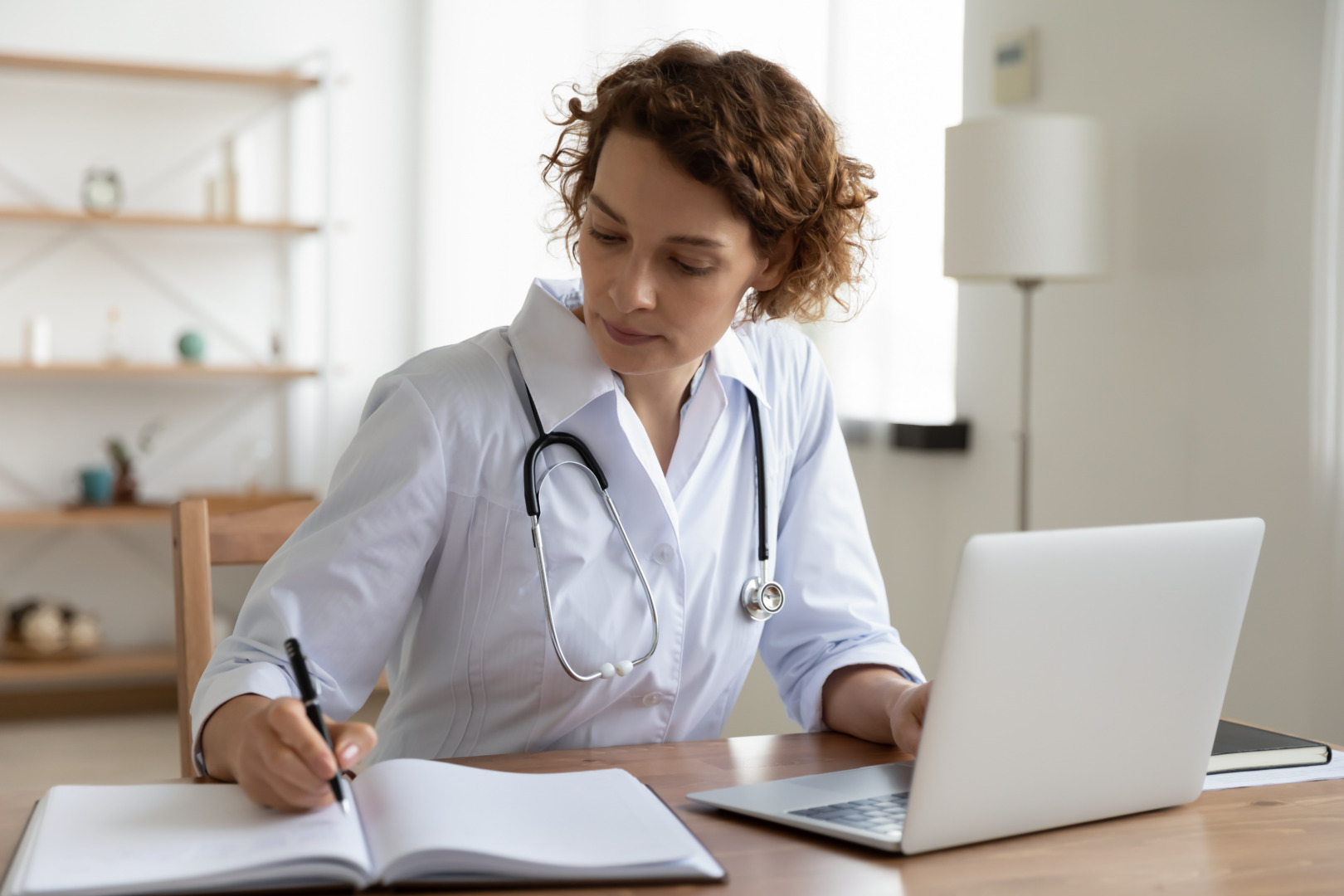 médica no consultório anotando em caderno