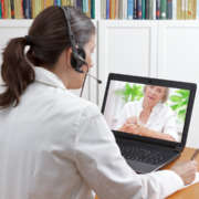 médica no computador com uma paciente fazendo laudo dermatológico online por telemedicina