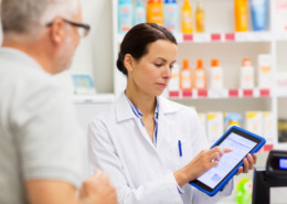 farmaceutica atendendo cliente na farmácia mostrando uma receita digital com através de um tablet