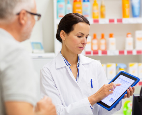 farmaceutica atendendo cliente na farmácia mostrando uma receita digital com através de um tablet