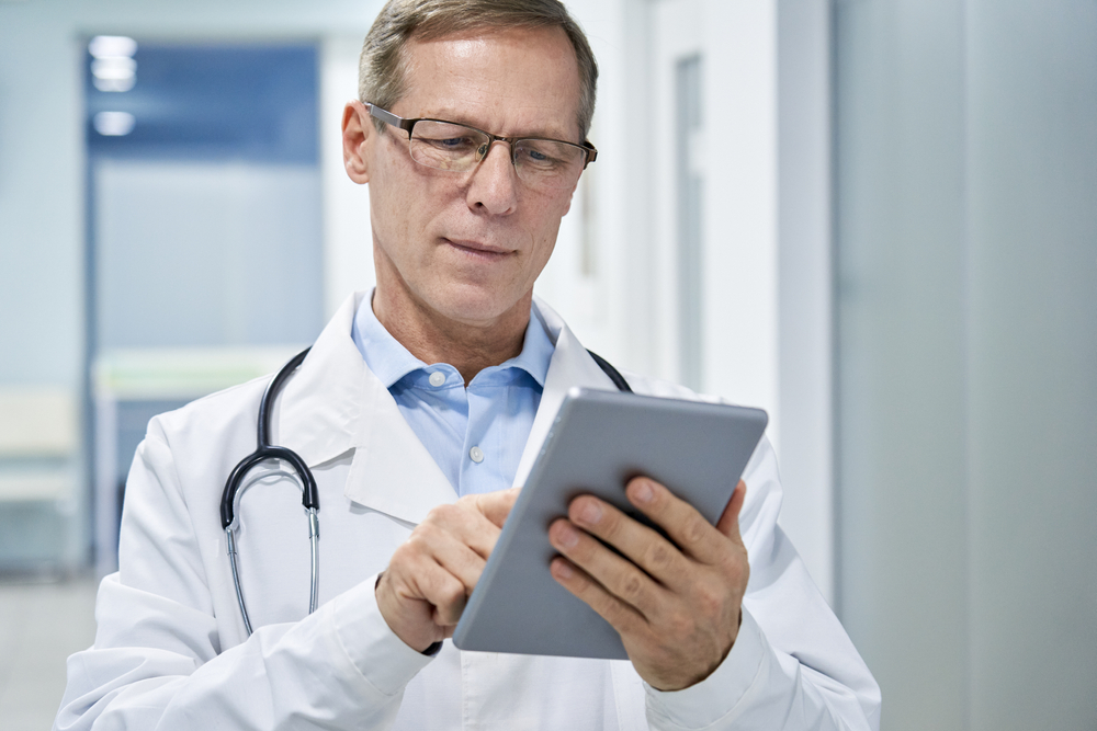 médico analisando exames em tablet