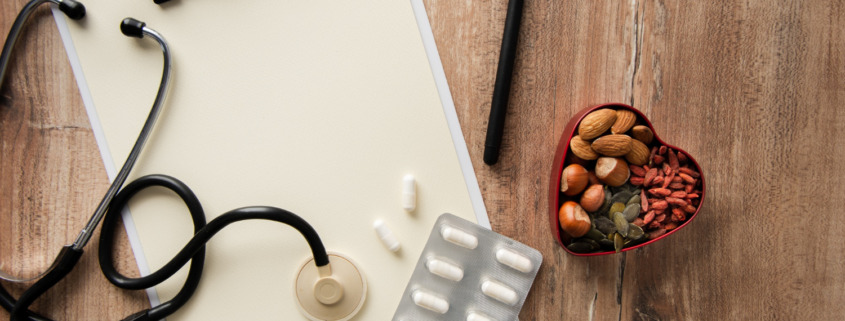 prancheta em branco com estetoscópio e medicamentos na mesa