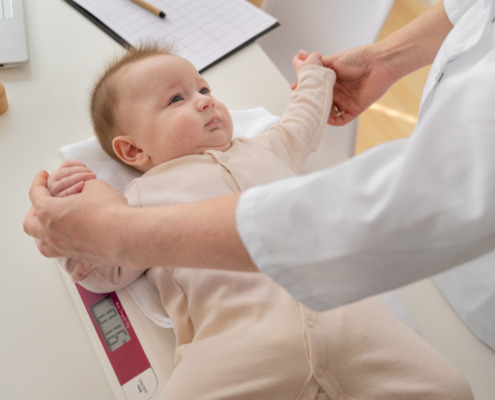 bebê sendo analisado por pediatra em consultório médico