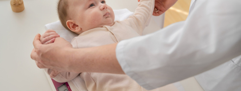 bebê sendo analisado por pediatra em consultório médico