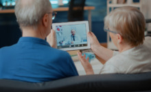 casal de idosos conversando com médico por tablet