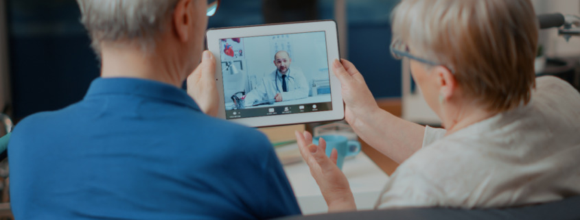 casal de idosos conversando com médico por tablet