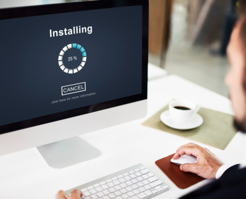 pessoa utilizando notebook com informação de "installing" na tela