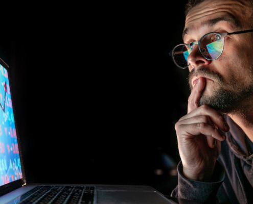 pessoa olhando para tela de notebook com gráfico de crescimento
