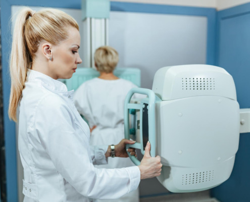 médica manuseando máquina de mamografia