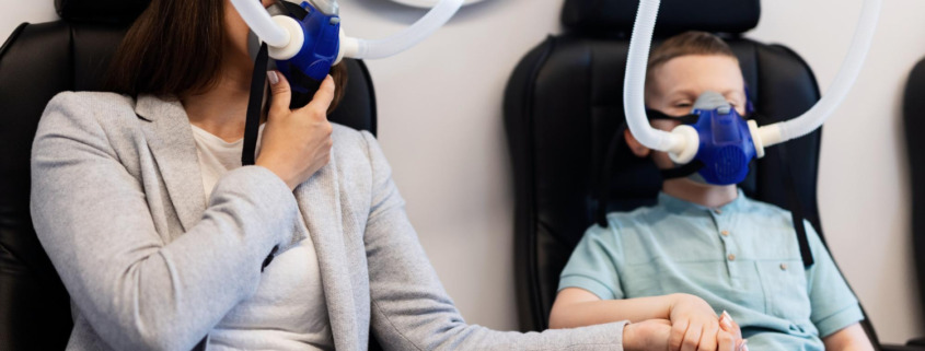 mãe e filho sentados tomando oxigênio