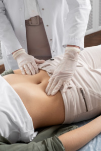 médico avaliando barriga de paciente