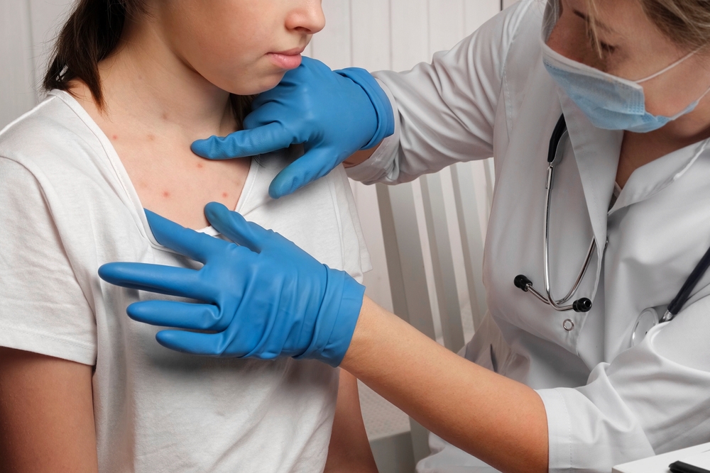médica de luva azul analisando corpo de menina