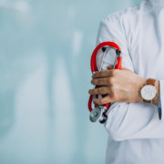 braço de médico com estetoscópio apoiado pela mão