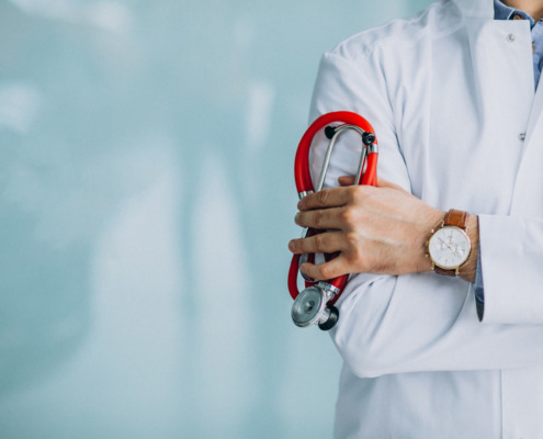 braço de médico com estetoscópio apoiado pela mão