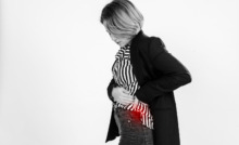 Mulher de perfil com mão na barriga e uma mancha vermelha simulando ponto da dor na barriga