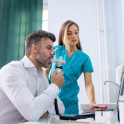 homem fazendo espirometria com enfermeira ao lado