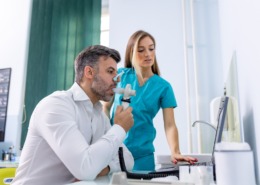 homem fazendo espirometria com enfermeira ao lado