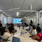 CEO da Portal Telemedicina lidera reunião apontando na tela dos dados com expectadores na sala