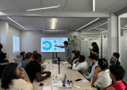 CEO da Portal Telemedicina lidera reunião apontando na tela dos dados com expectadores na sala