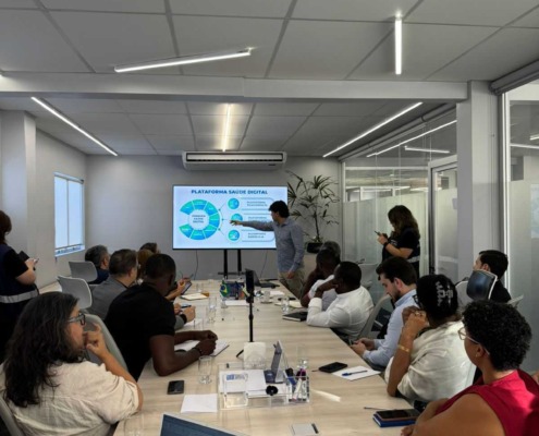 CEO da Portal Telemedicina lidera reunião apontando na tela dos dados com expectadores na sala