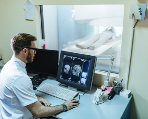médico na sala de tomografia acompanha paciente fazendo exame