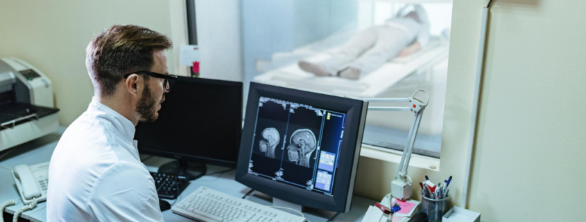 médico na sala de tomografia acompanha paciente fazendo exame