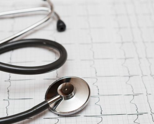 estetoscópio apoiado em cima de exame de ECG