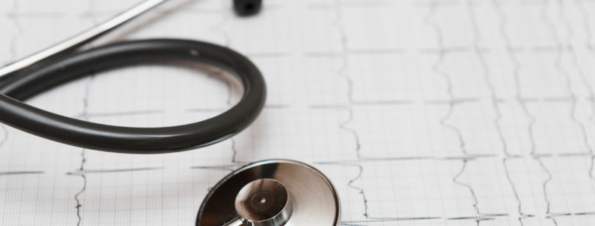 estetoscópio apoiado em cima de exame de ECG