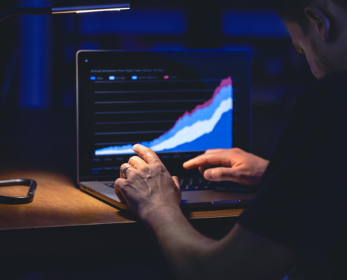 pessoa utilizando notebook com gráfico em subida