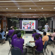 pessoas reunidas em auditório com telão de apresentação