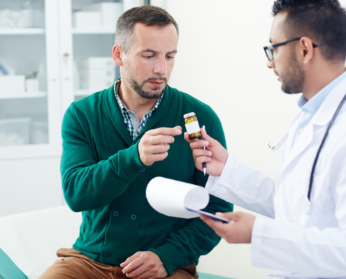 paciente no consultório com médico dando comprimido