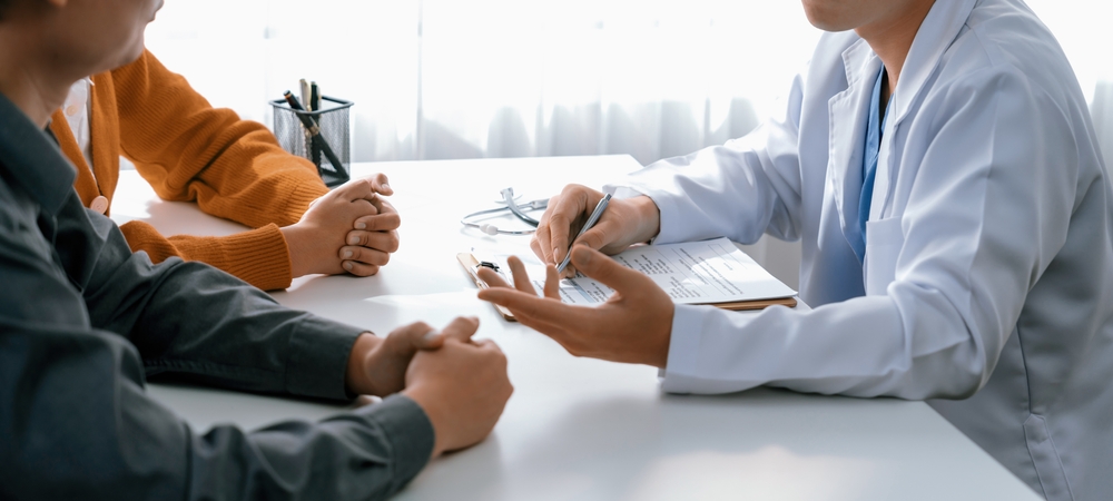 mãos de médico e pacientes em mesa do consultório médico