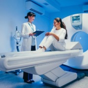 paciente sentada em máquina de ressonância com médica atendendo