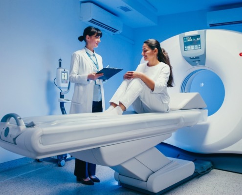 paciente sentada em máquina de ressonância com médica atendendo