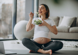 mulher grávida sentada comendo salada