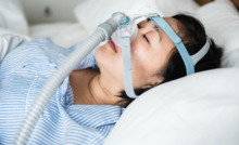 mulher deitada na cama com o aparelho CPAP