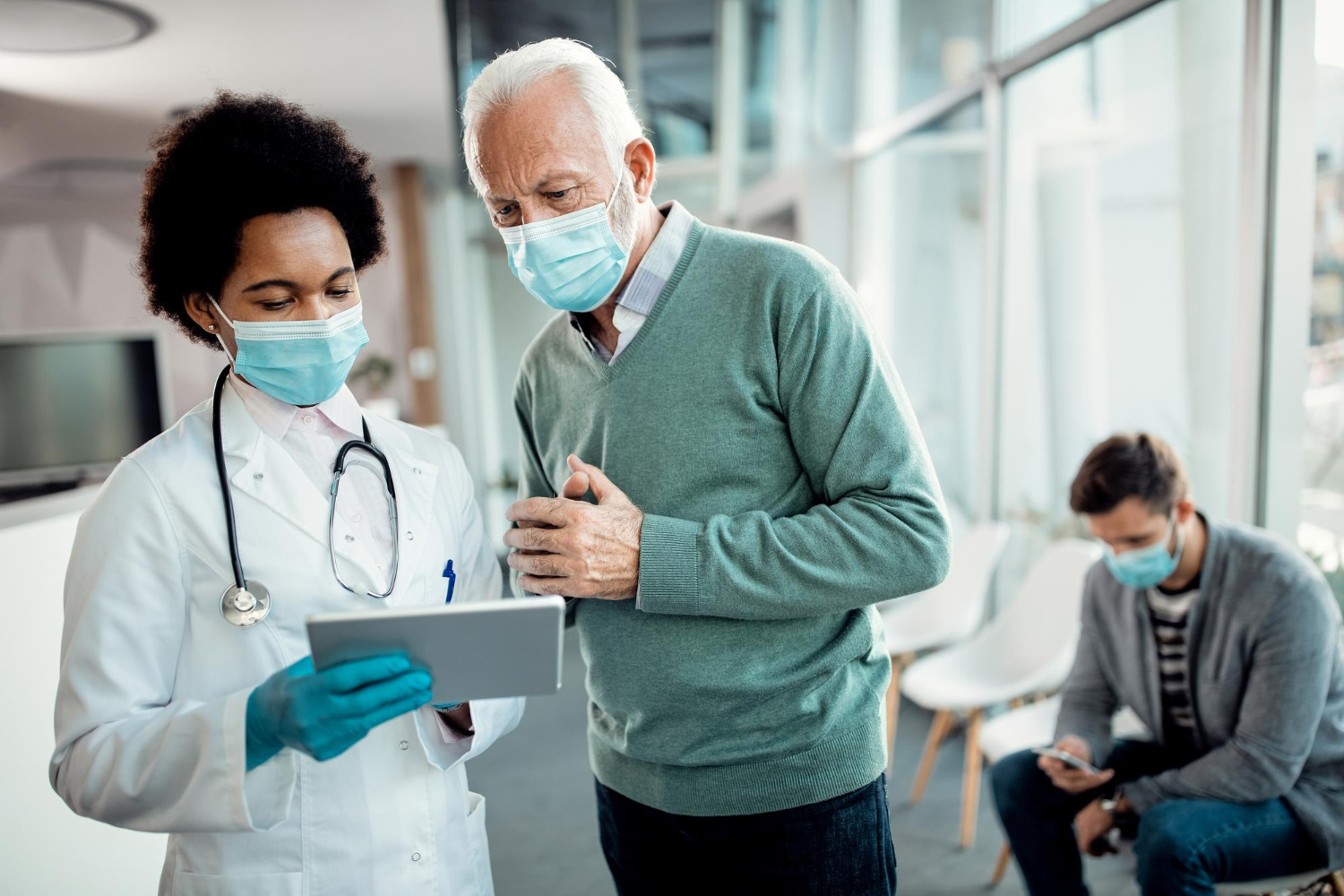 médica orientado paciente mostrando informação no tablet