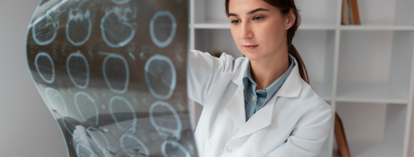 médica de jaleco branco analisando exame de imagem