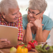 avaliacao-nutricional-para-idosos casal de idosos apoiando na mesa com legumes em sua frente