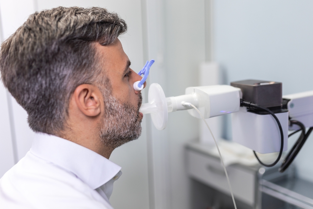 homem sentado fazendo exame de espirometria