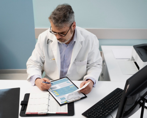 médico sentado em consultório, anotando formulário