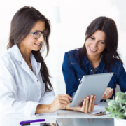 médica avaliando dados no tablet com mulher ao lado junto