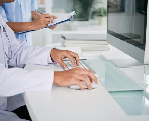 médicos em bancada na frente do computador