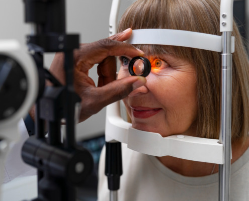 idosa faz exame de vista em aparelho dentro do consultório médico