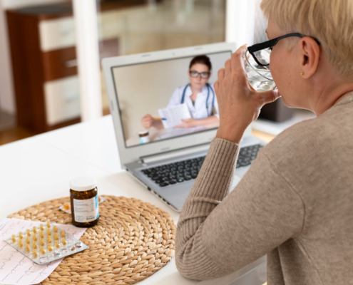 idosa em residência fazendo teleconsulta no notebook