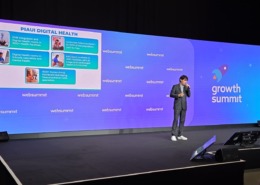 homem palestrando em palco de evento com painel com slide ao fundo